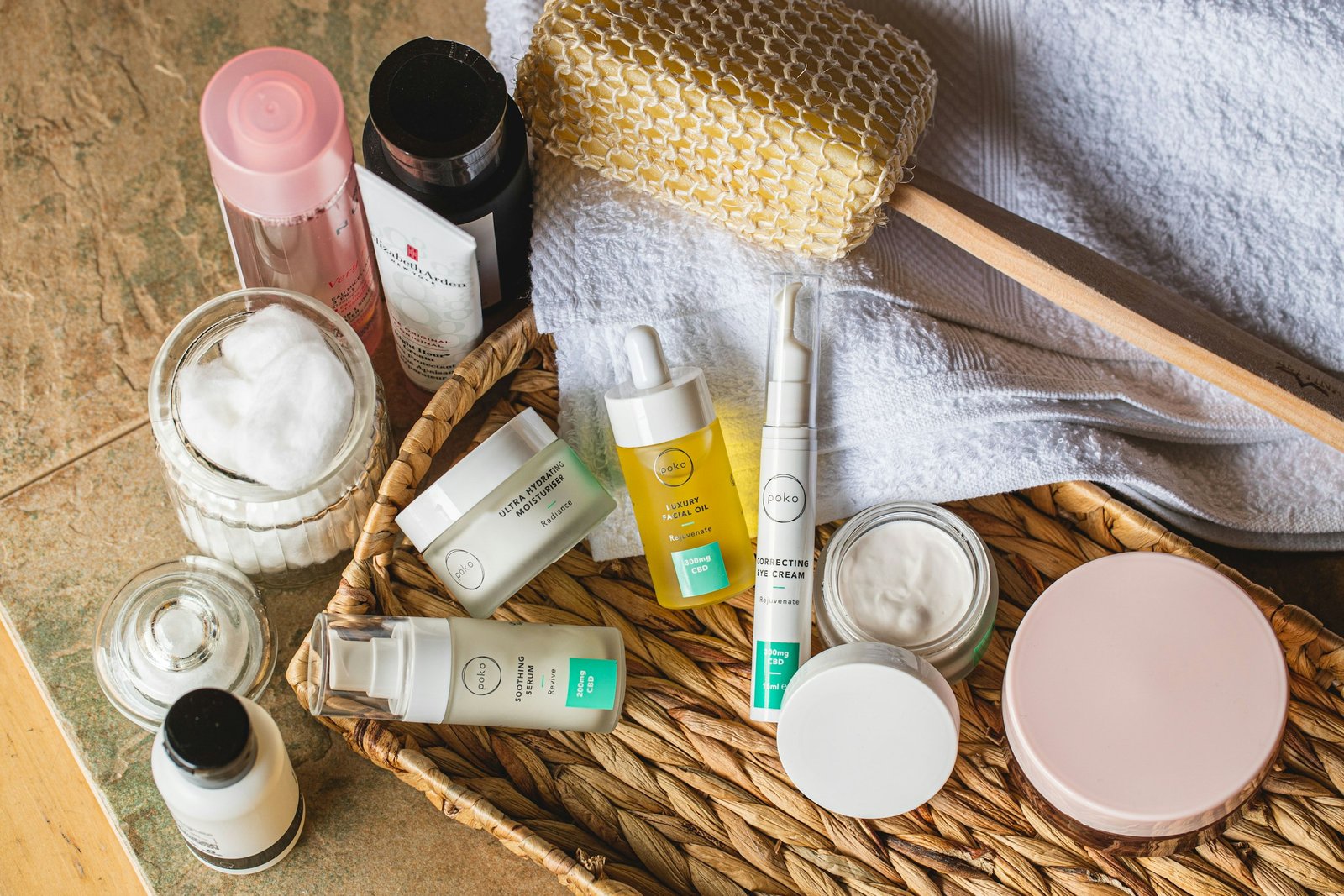 Luxury travel size toiletries and skincare minis in a woven basket next to a towel
