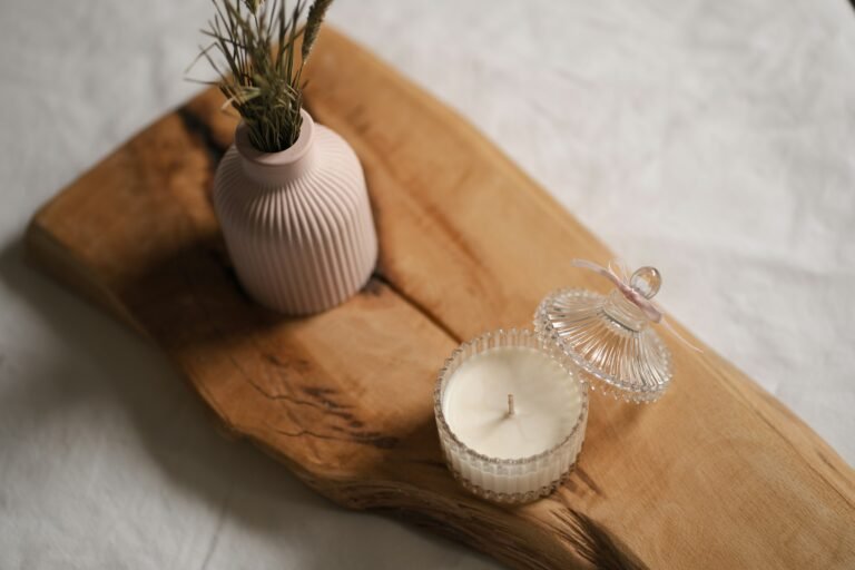 Mahogany teakwood candle mood: a jar candle and vase on a natural wood board