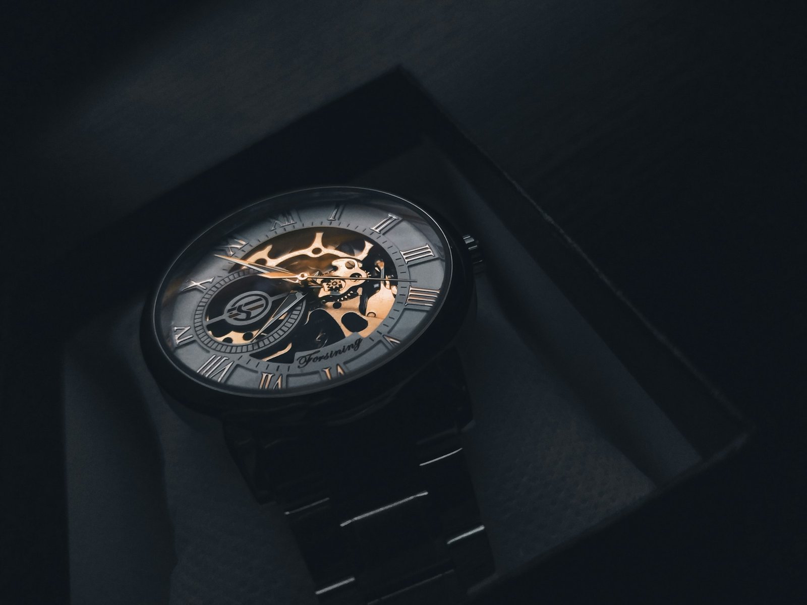 OLEVS automatic watch review: a skeleton automatic watch with Roman numerals resting in a gift box