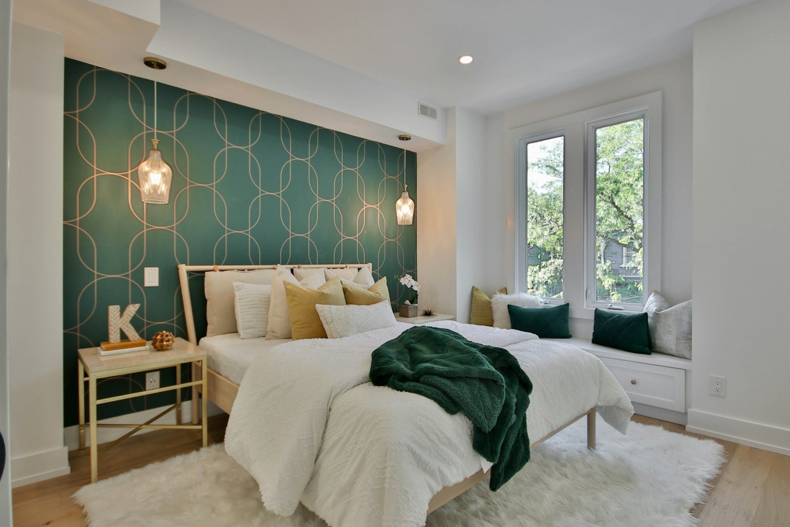 Olive green velvet quilt idea: a bright bedroom with a deep green throw over white bedding and green accent pillows