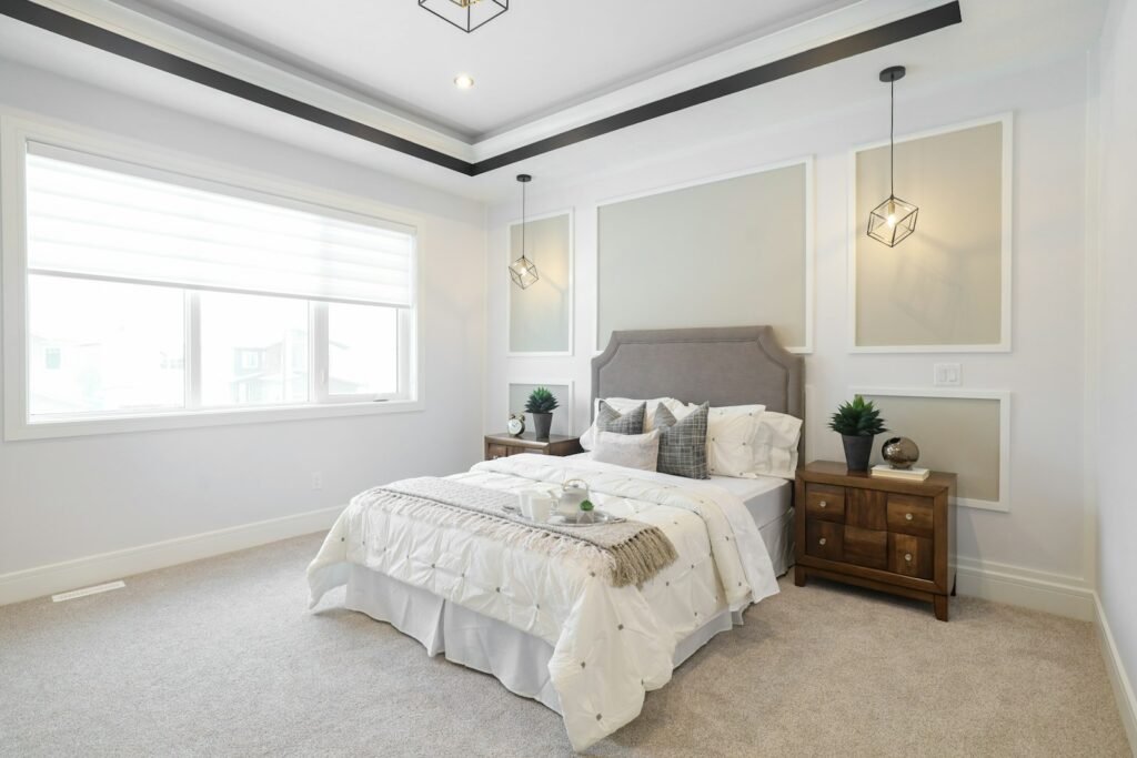Velvet quilted bedspread styling: a quilted coverlet layered on a king bed in a bright neutral bedroom
