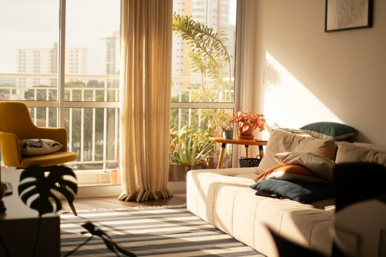 One way window film idea: sunny living room with tall glass windows and linen curtains