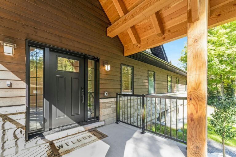 Outdoor door mat style idea: a black front door with a mat on a wooden porch