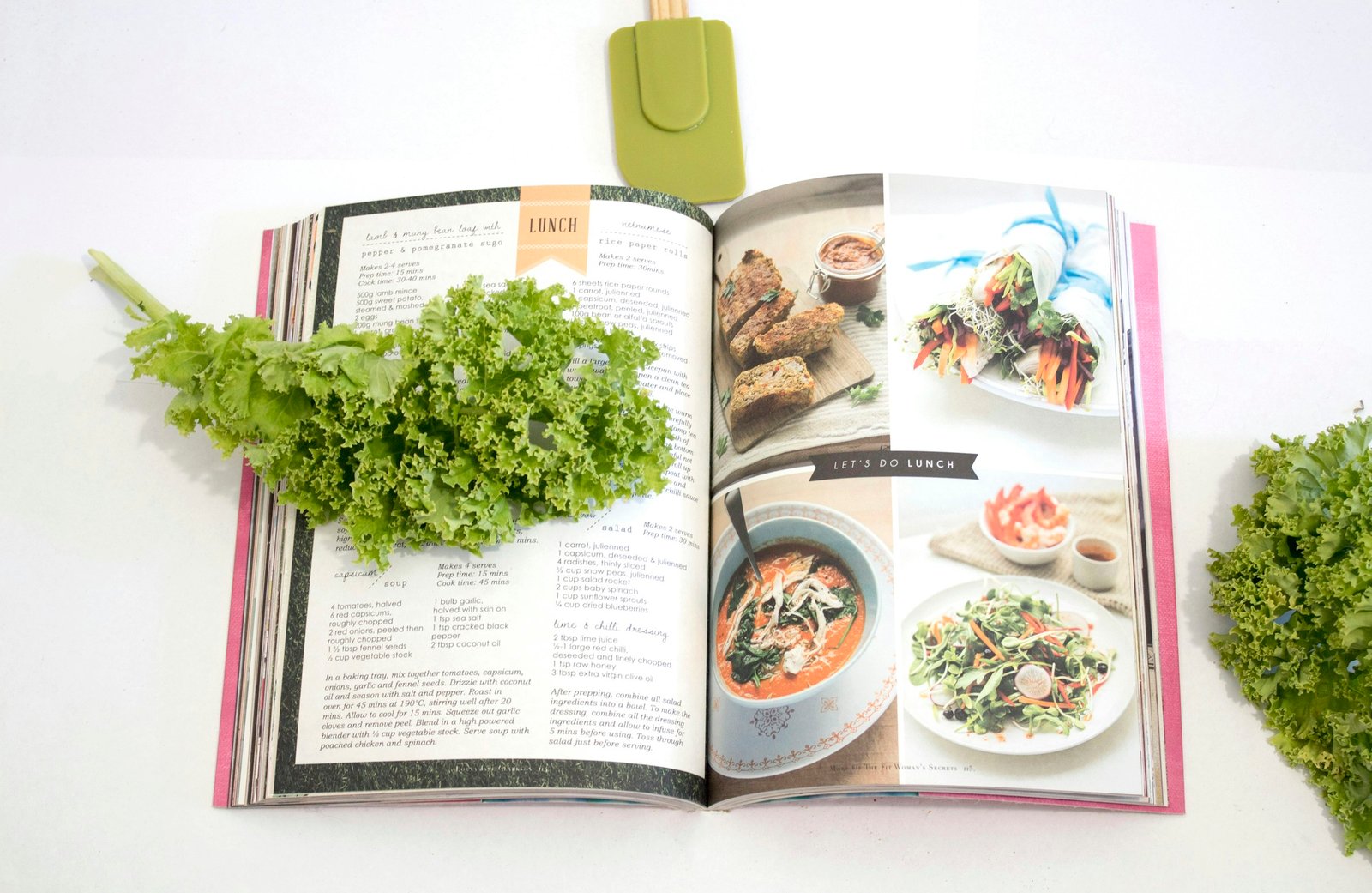 Personalized recipe box and cards: an open cookbook with family recipes and fresh greens on a white table