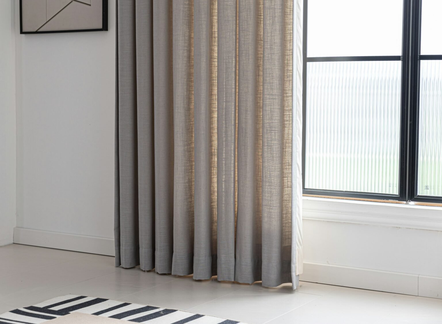 Pinch pleat curtains style: natural linen curtains framing a bright window