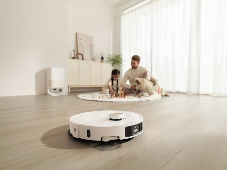 Roomba vs Roborock: a white robot vacuum and mop cleaning a bright living room floor while a family plays