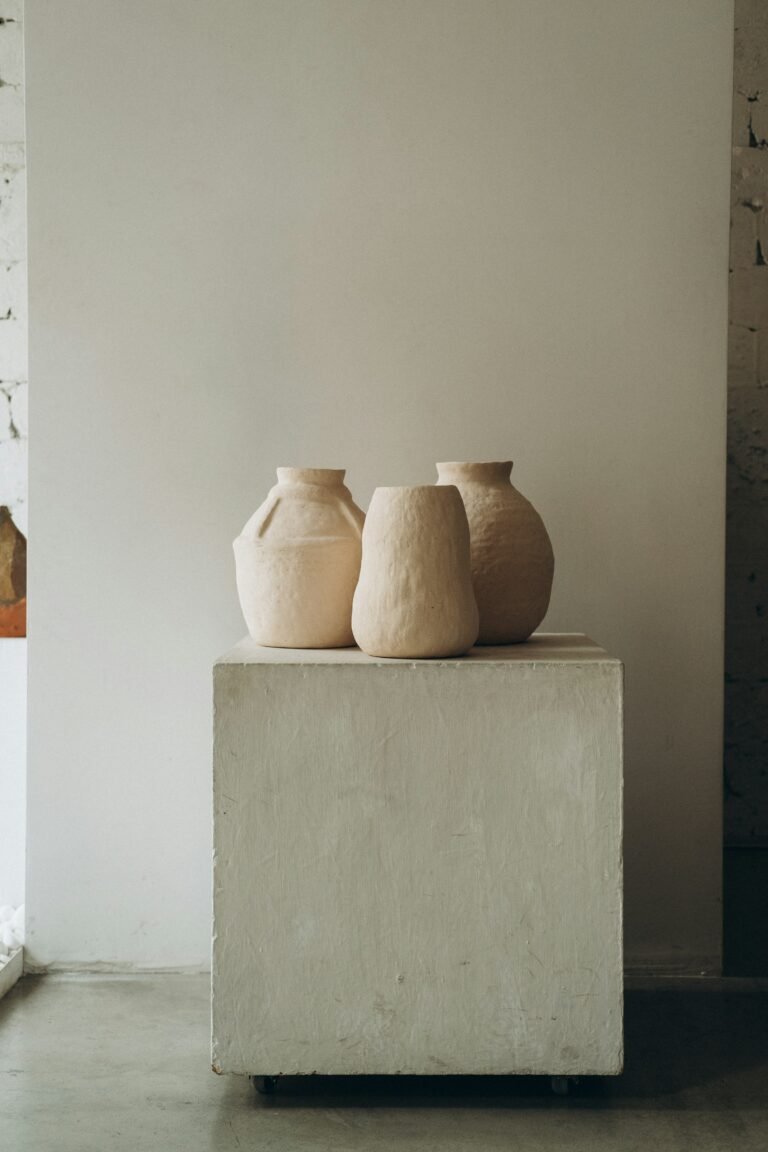 Small rustic ceramic vase on a white wooden shelf