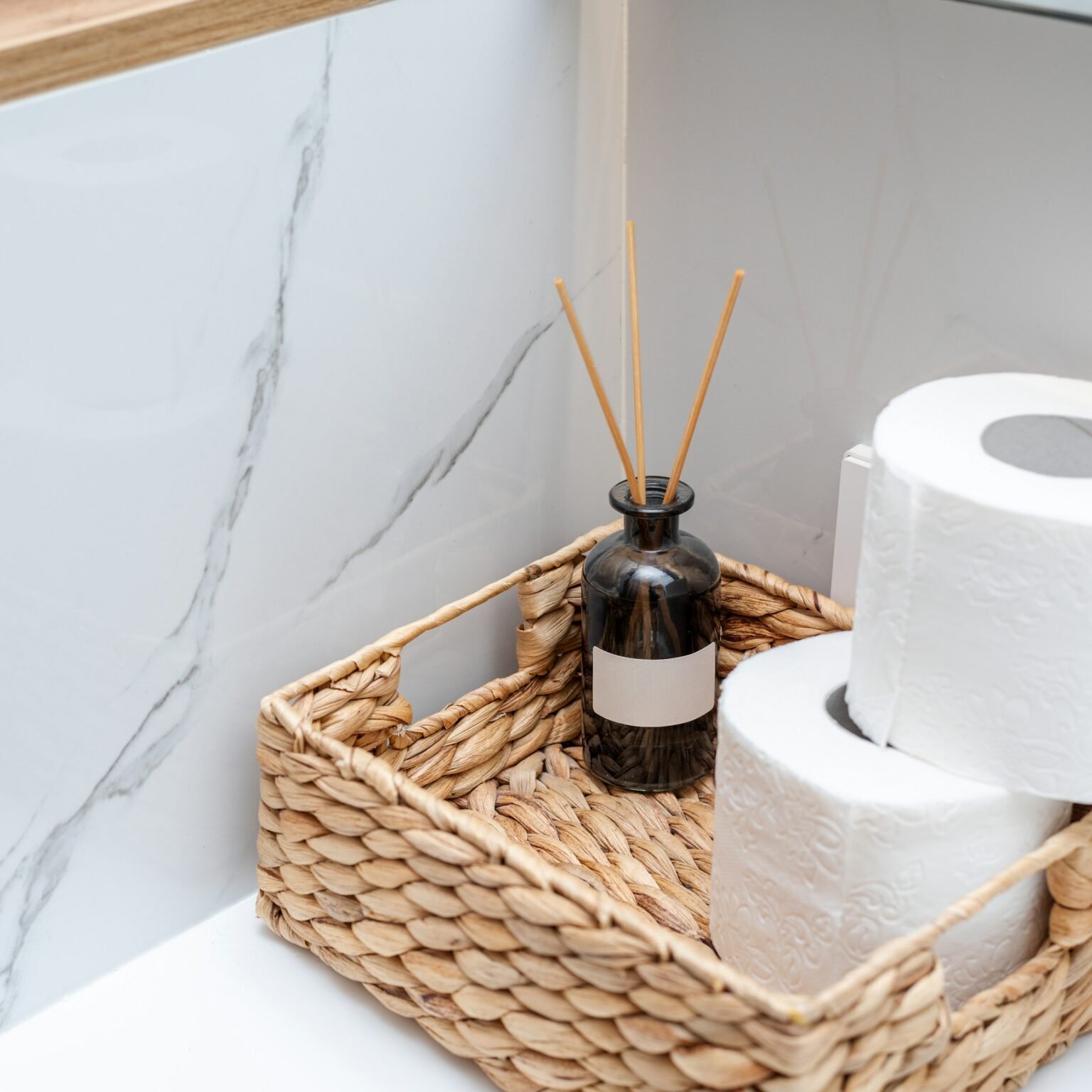 Woven basket holding toilet paper rolls, a scalloped storage basket use