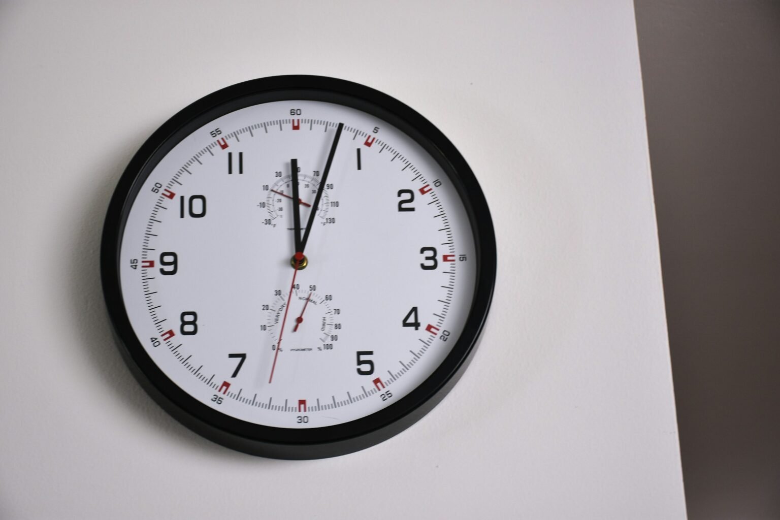 Silent wall clock styling: a black framed round clock on a white wall