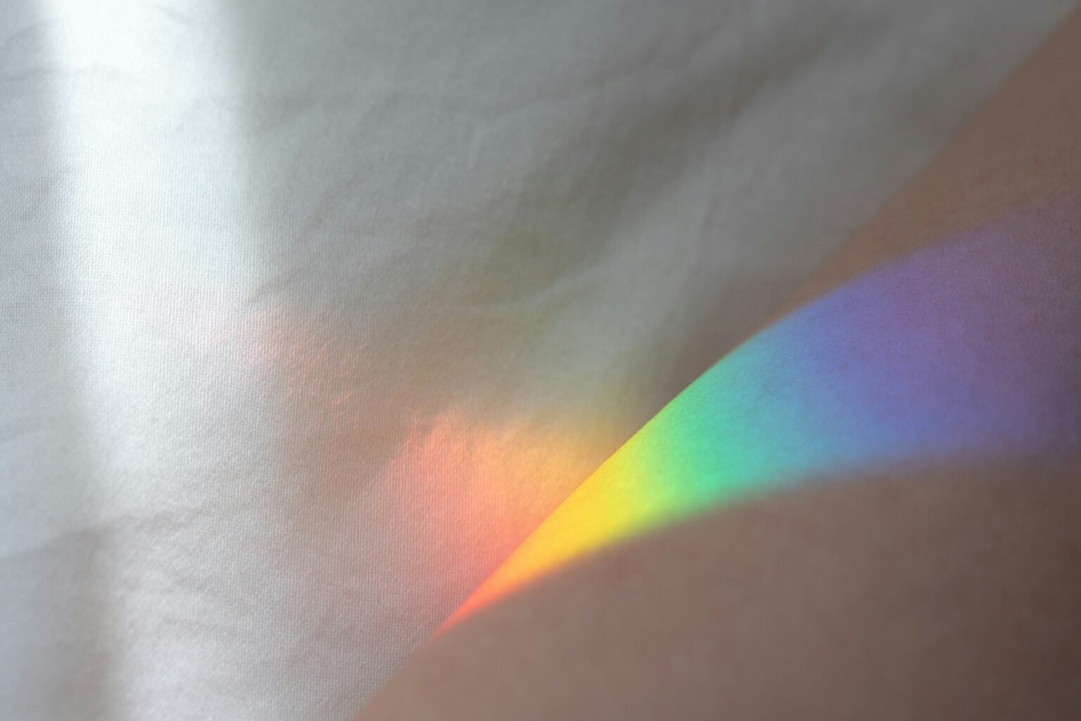 Rainbow window film glow: a soft rainbow of sunlight falling across a white surface