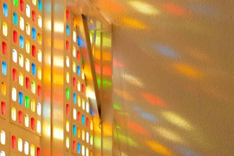 Stained glass window film effect: colored sunlight patterns cast on a bright wall