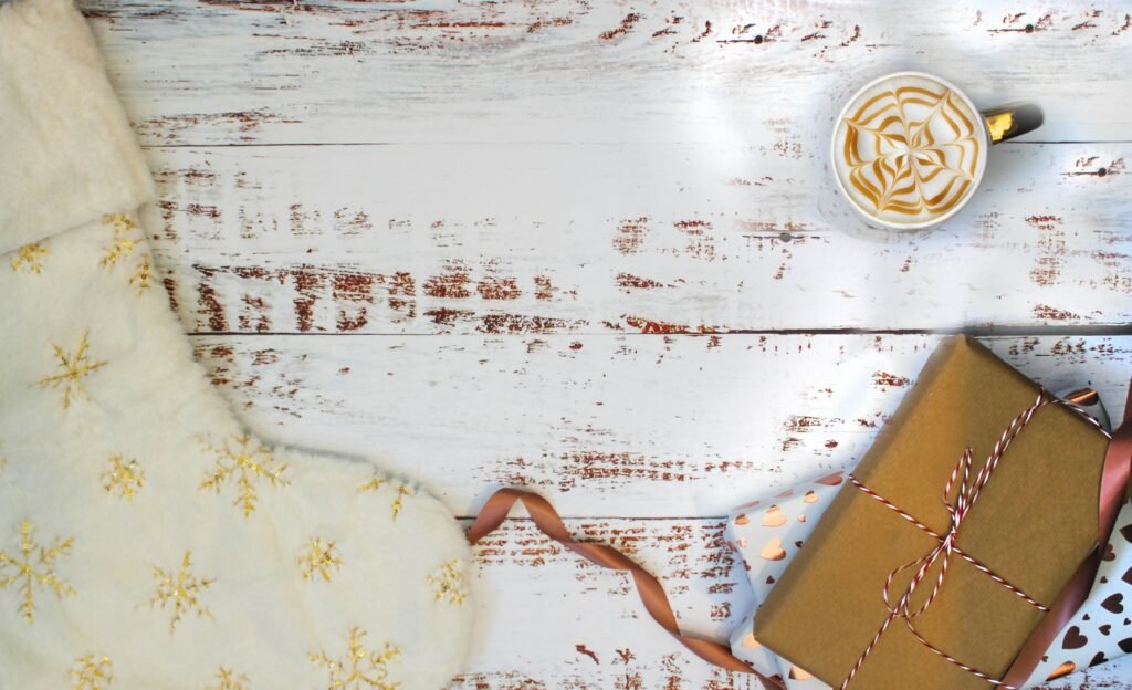 A snowflake stocking and a kraft-wrapped gift on white wood, ideas for stocking fillers for men