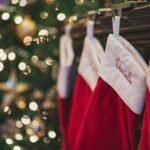 Stocking stuffers for teen girls: personalized red and white Christmas stockings hanging by the tree