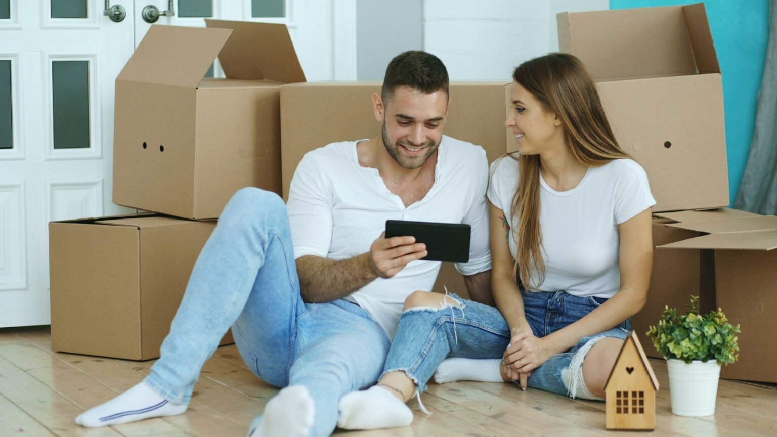 Couple looking at a tablet among moving boxes