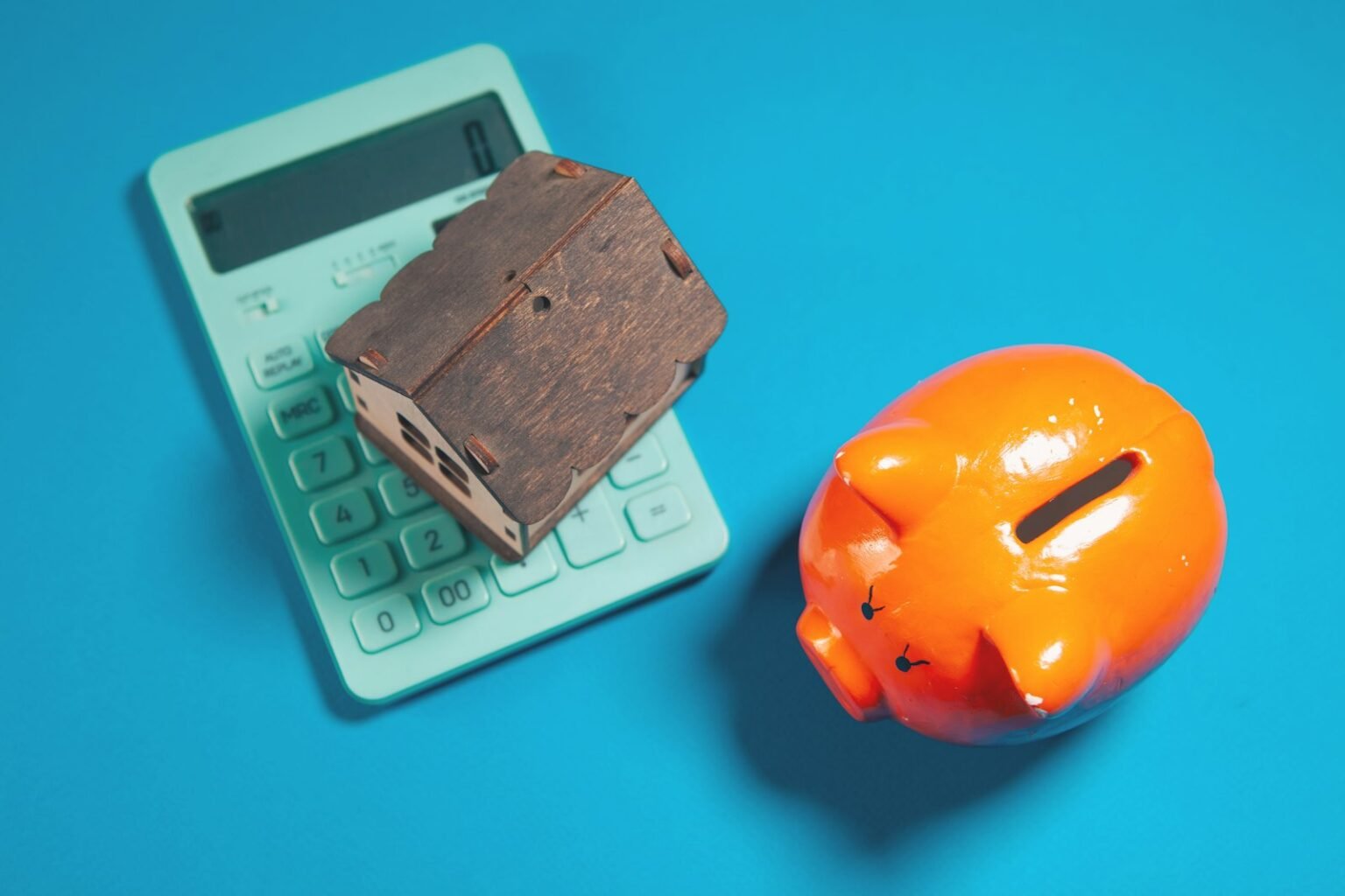 Calculator, piggy bank and house model