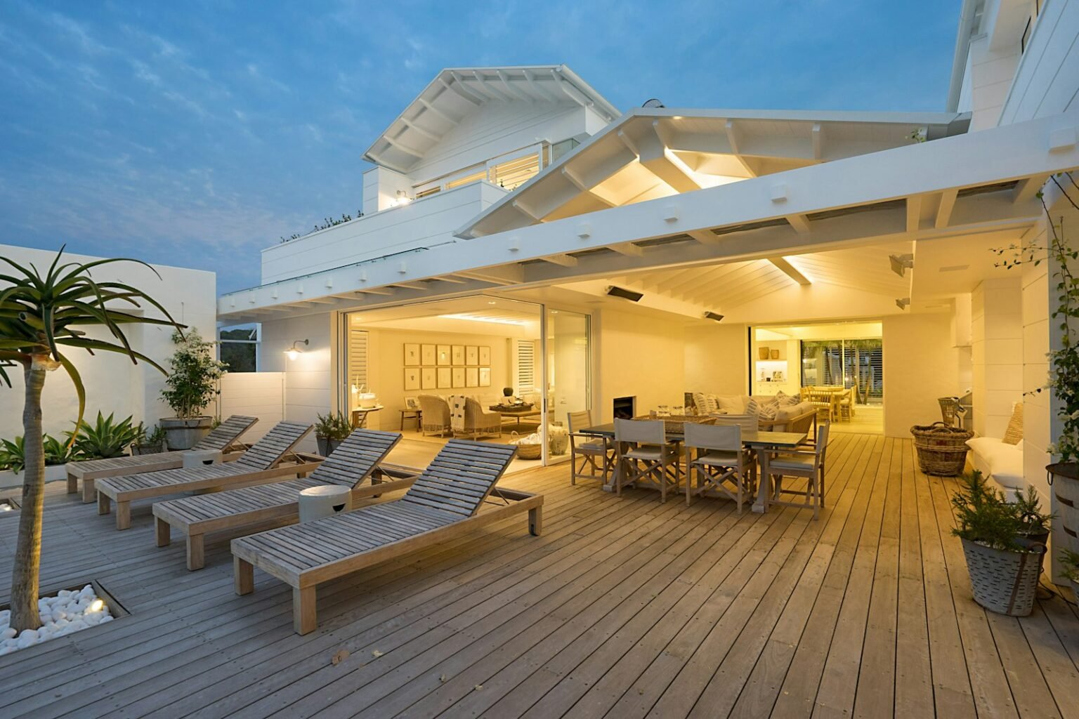 White bench on a deck near a house