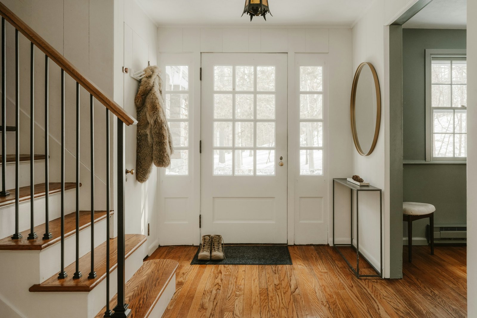 Cozy entryway with wooden stairs and a glass door