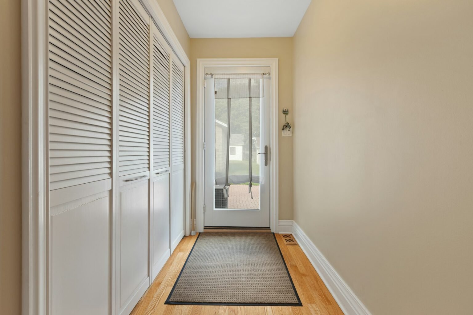 Hallway with a door and a rug
