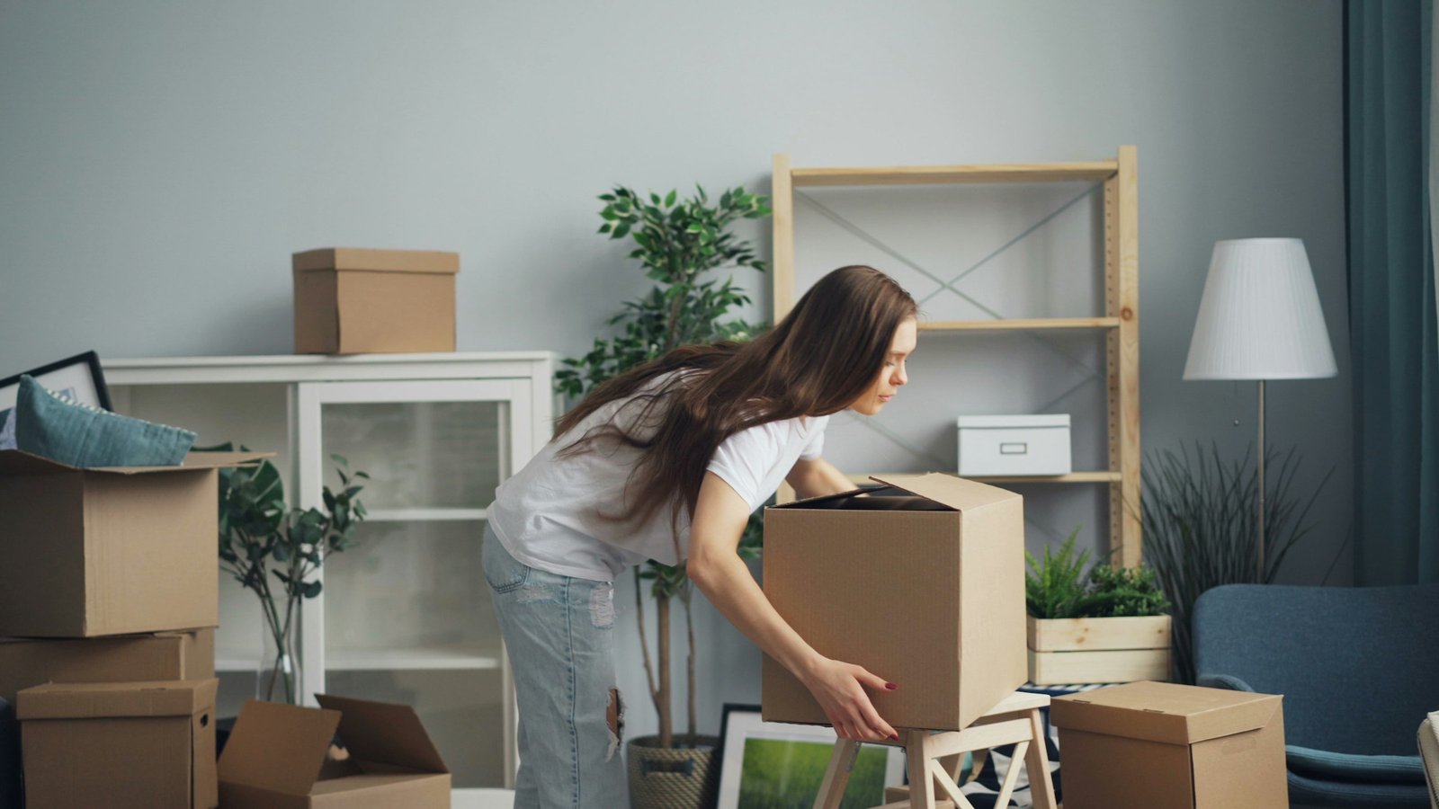 Person moving boxes in a living room