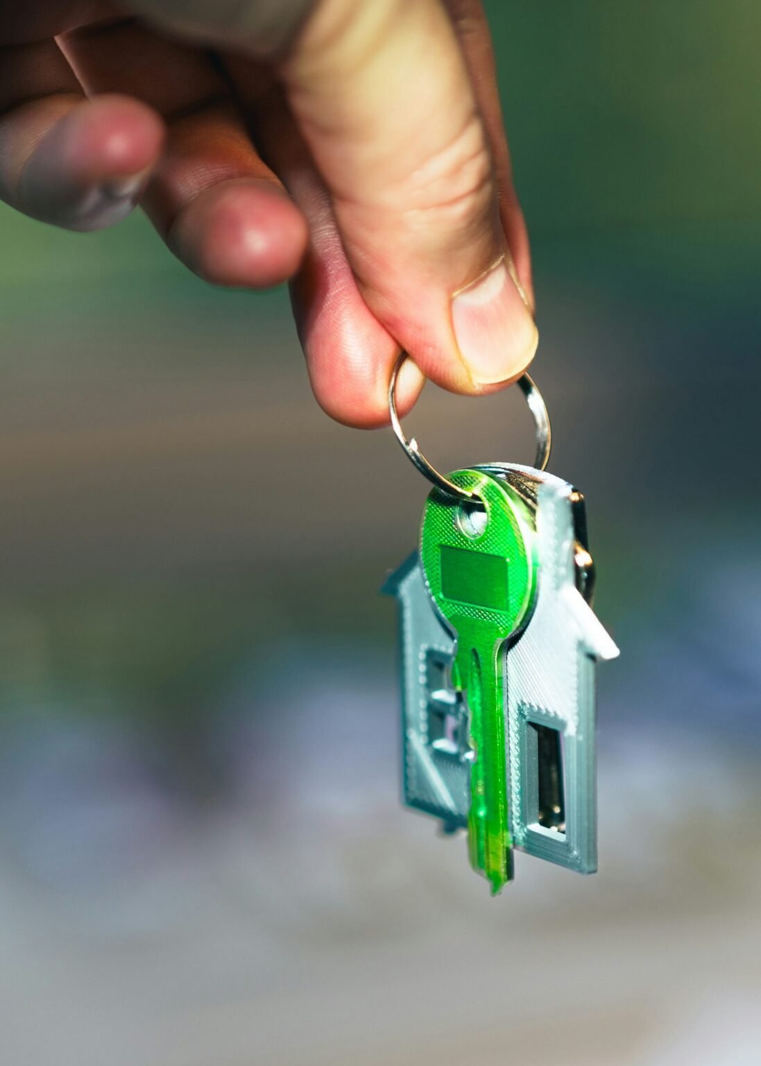 Hand holding a green house key