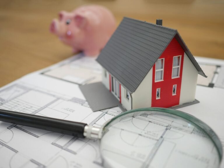 Model house beside a magnifying glass