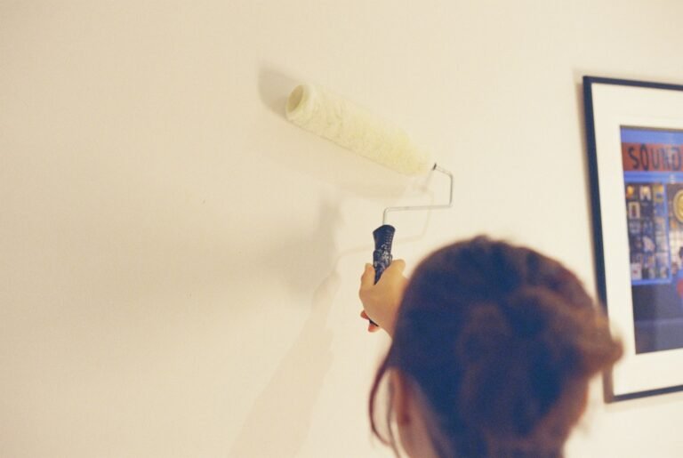 Person painting a wall with a roller