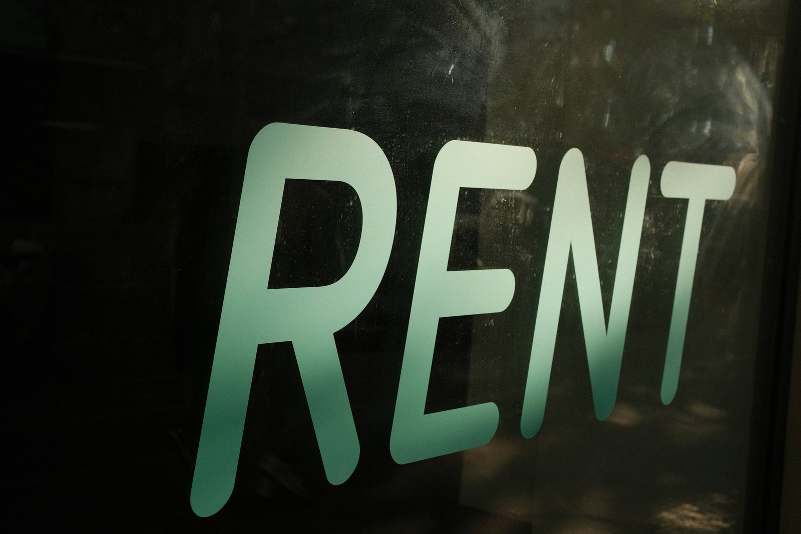 The word rent written on a dark surface