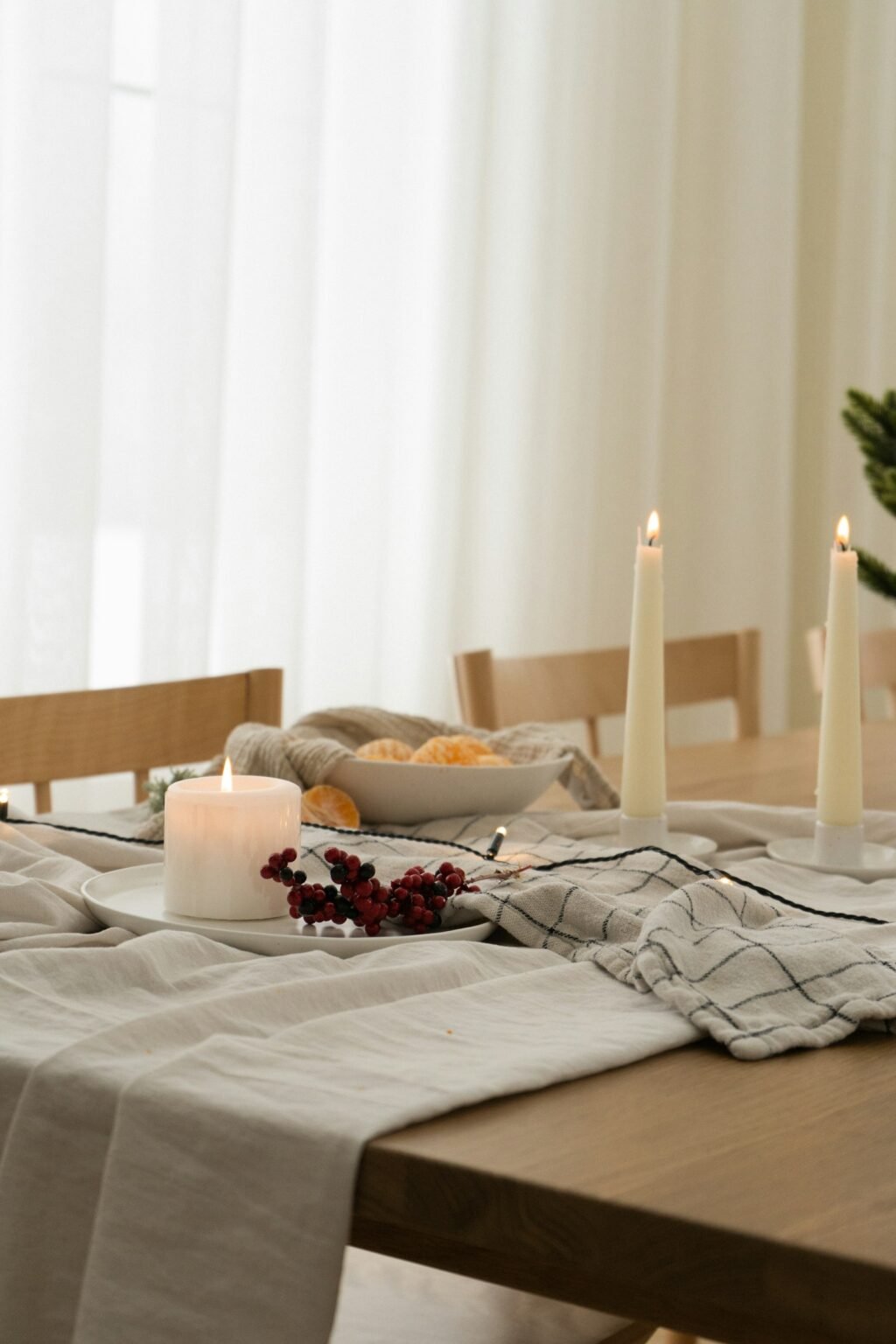 Wooden table with candles and a bowl of fruit