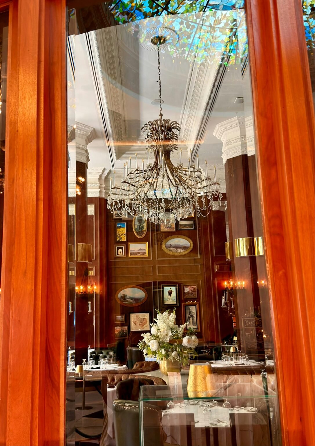 2026 home decor trends – Crystal chandelier in a wood-paneled dining room