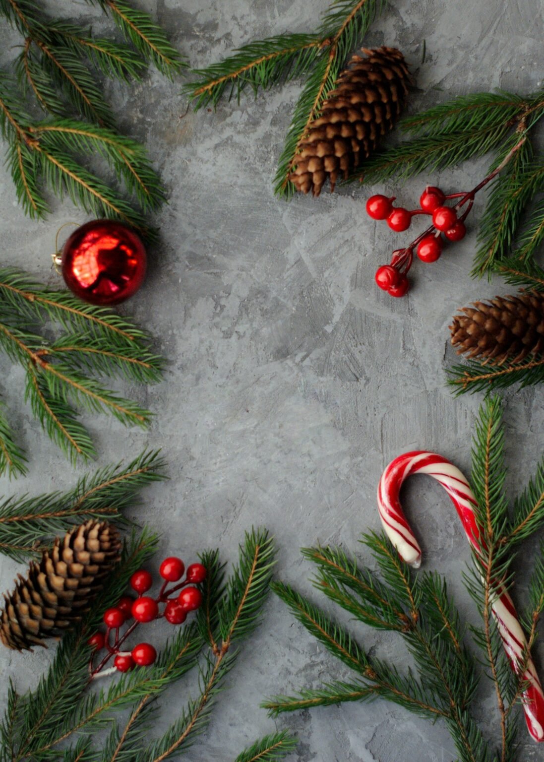 Flat lay of pinecones, candy canes and greenery