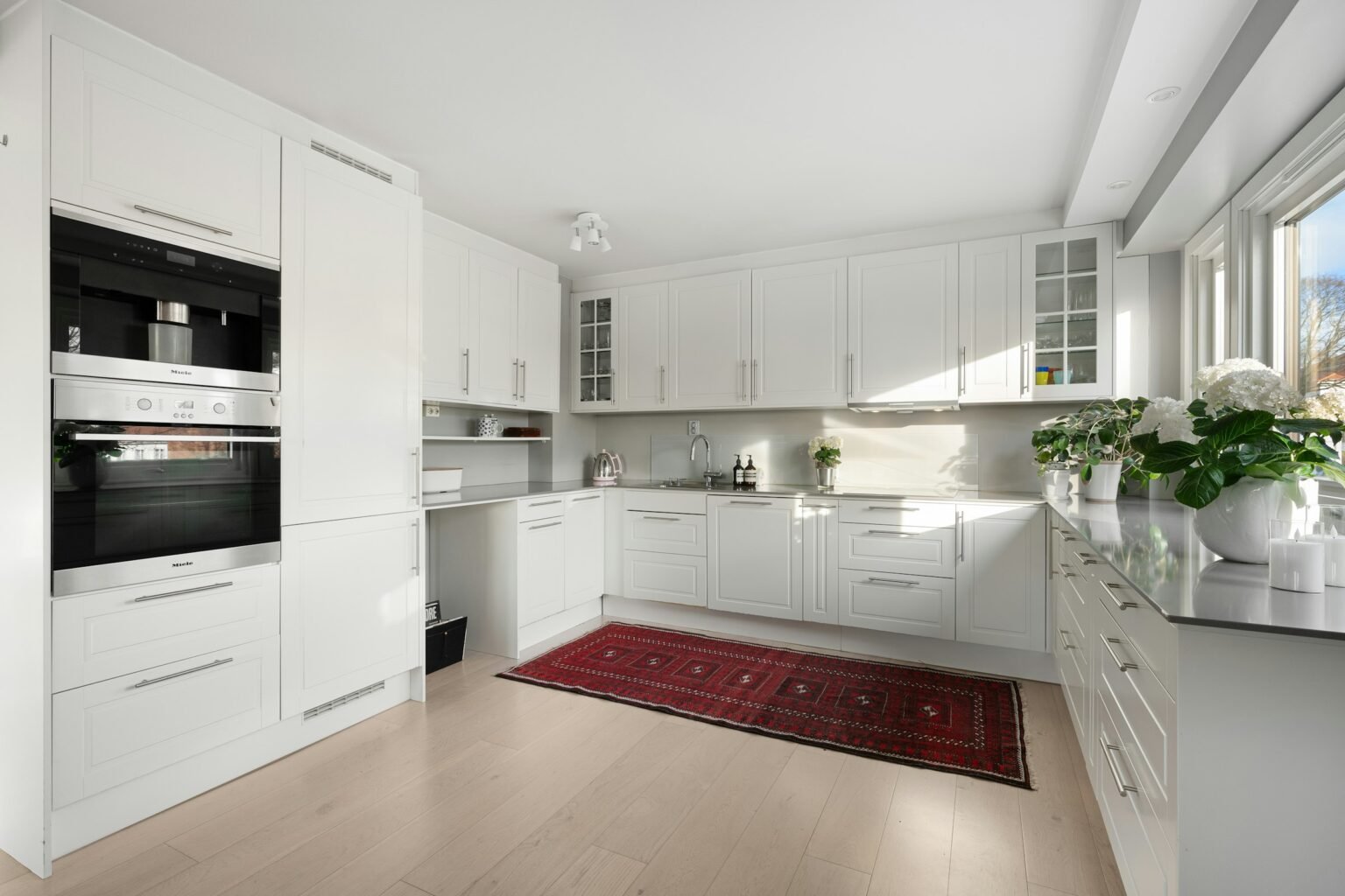 White kitchen with a red rug on the floor