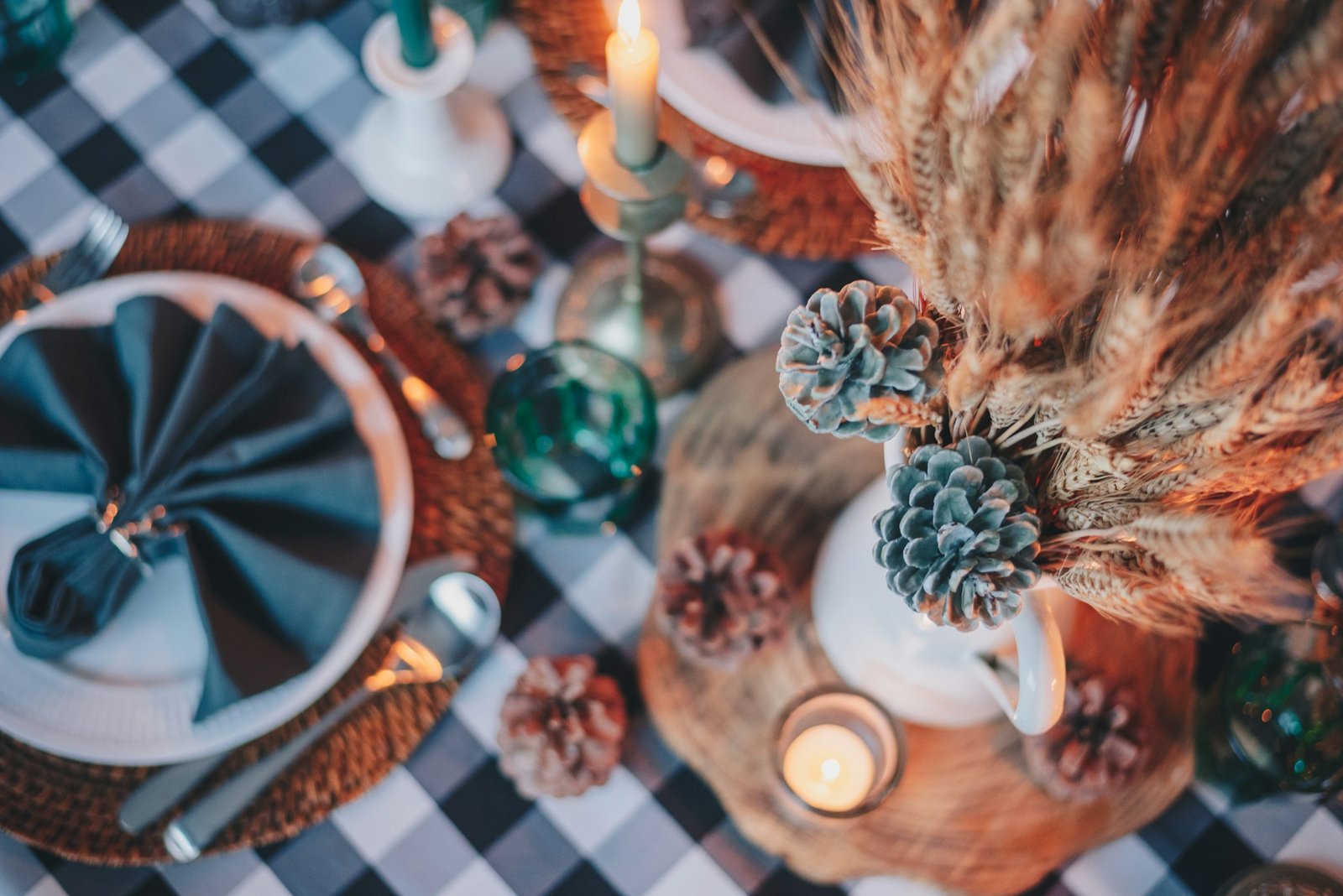 Thanksgiving centerpiece ideas with candles and a glass vase on a dining table