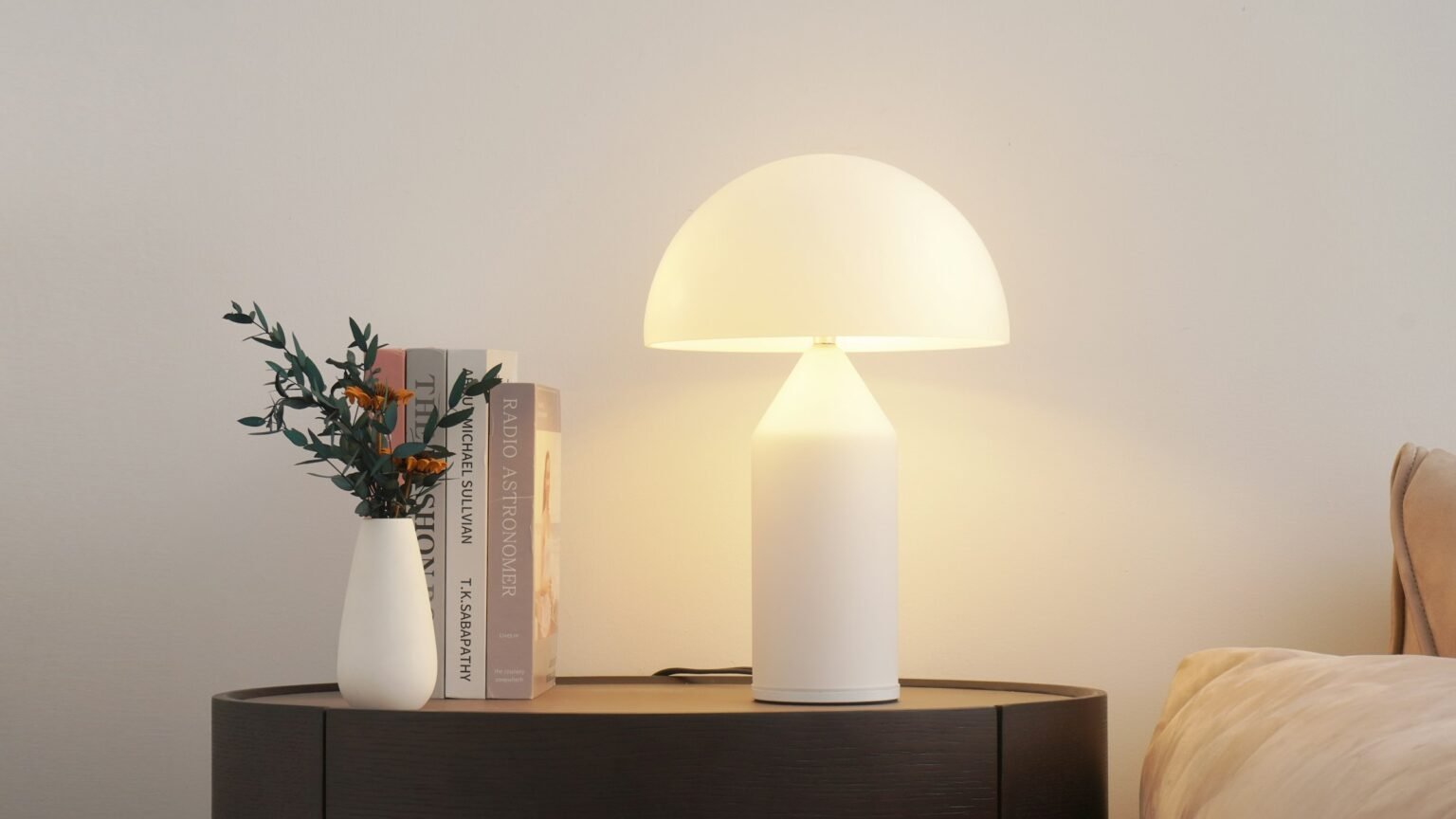 Touch bedside lamp glow next to a vase and books