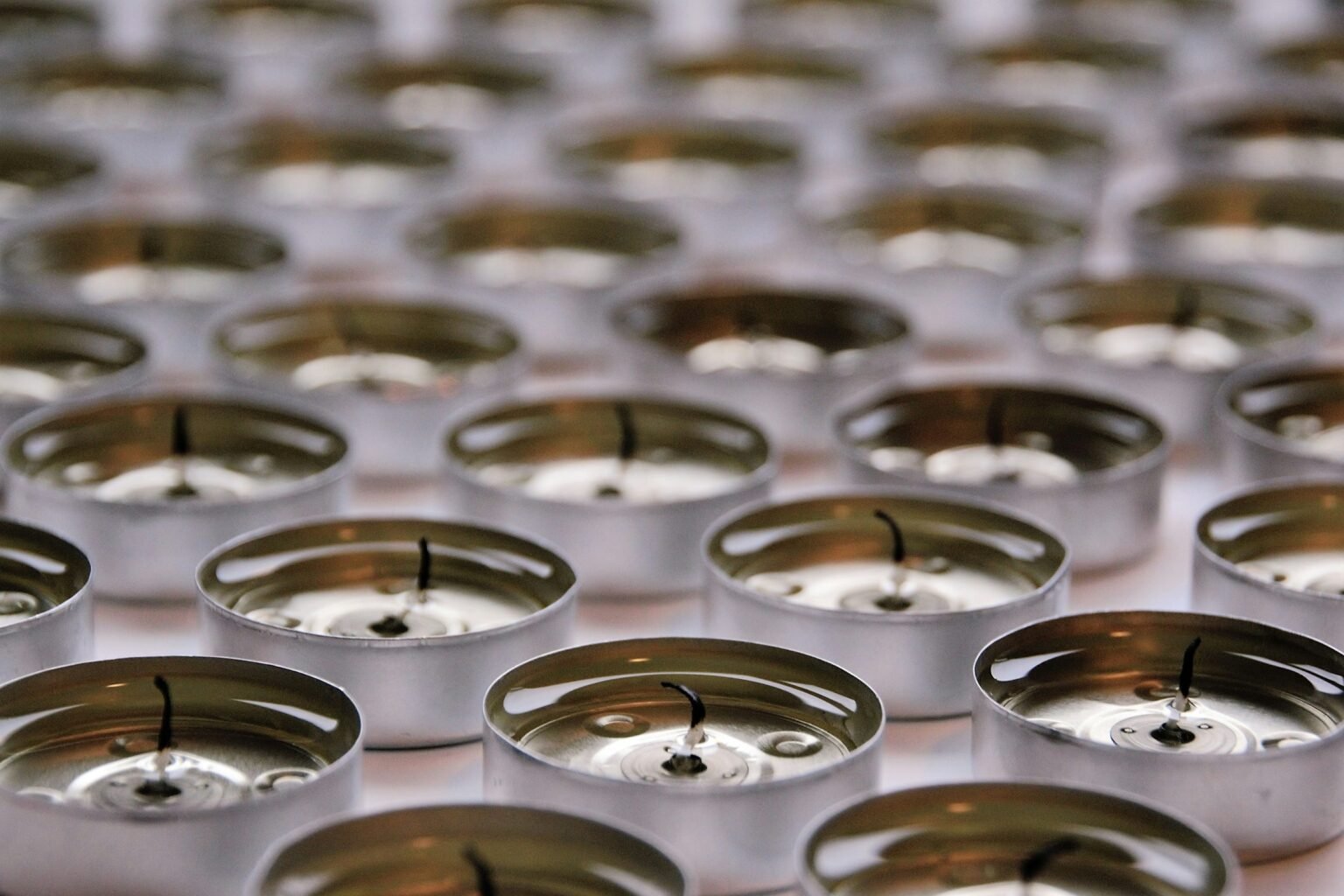 Unscented tea light candles in silver aluminum cups lined up in rows