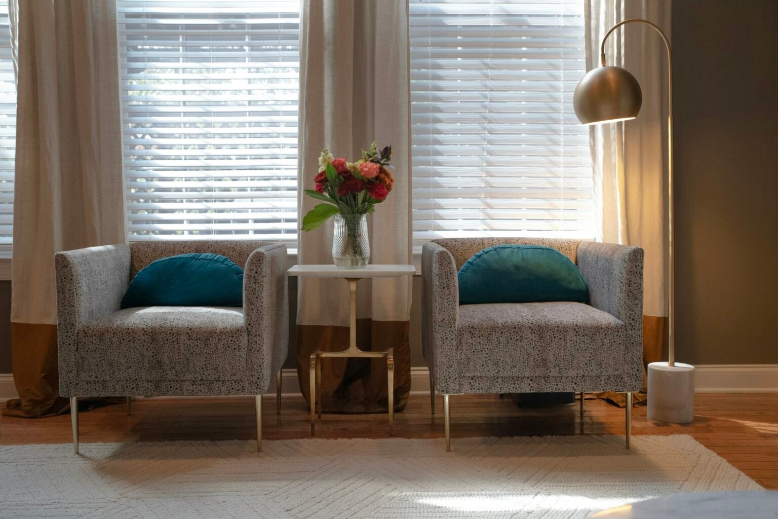 Small end table between two chairs in a bright living room