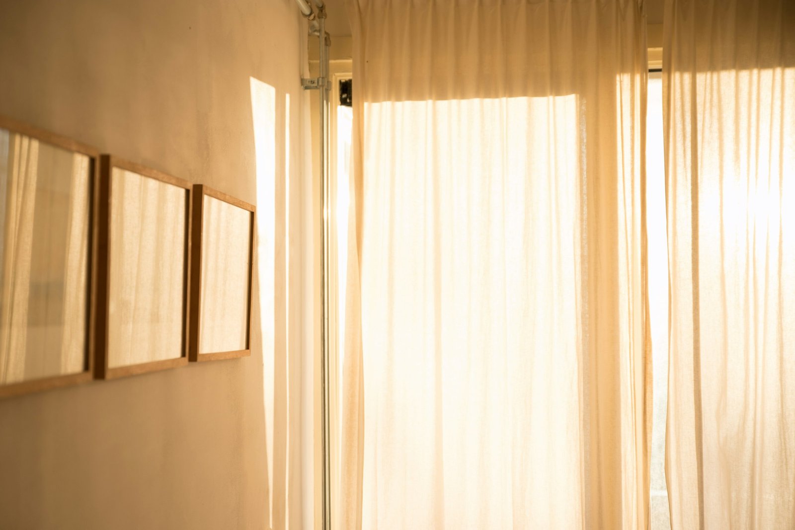 White sheer curtains glowing with warm sunlight in a bright room