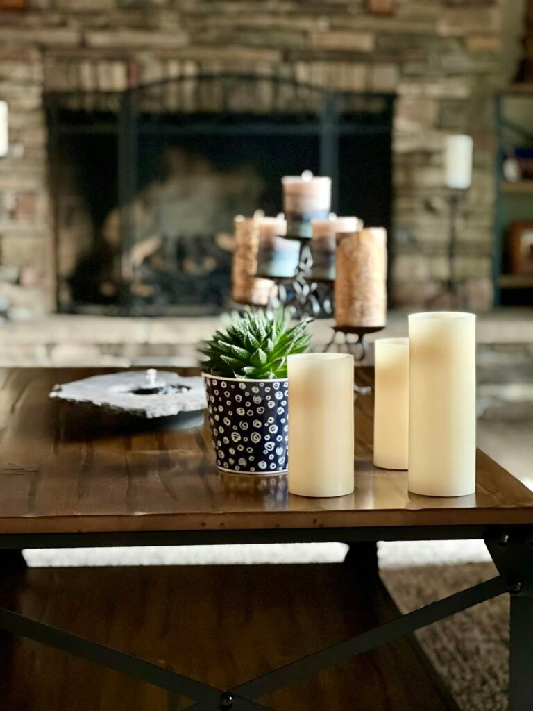 Table with candles and a plant grouped like a wooden candle tray display