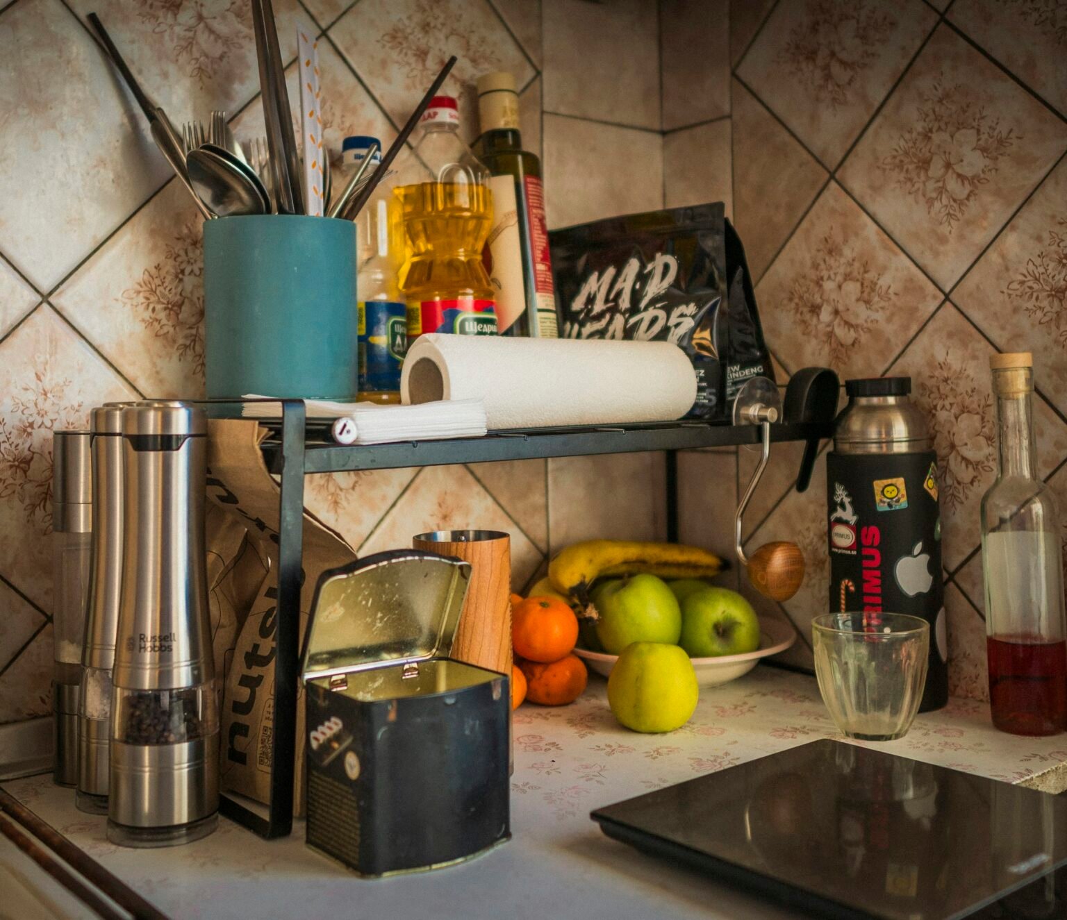 Kitchen counter with fruit and utensils, a spot for a wooden paper towel holder